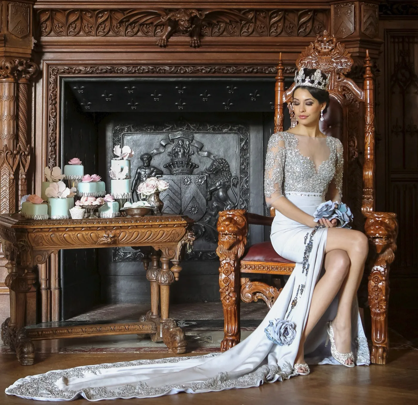 Erato. A bride seated on a carved throne in a beaded couture gown with a long embroidered train.